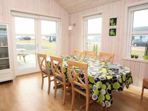 comedor con mesa, sillas y ventanas en Three-Bedroom Holiday home in Løkken 40, en Løkken