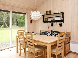 ein Esszimmer mit einem Holztisch und Stühlen in der Unterkunft 7 person holiday home in lb k in Ålbæk