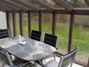 a wooden table and chairs on a patio at Three-Bedroom Holiday home in Idestrup 5 in Marielyst
