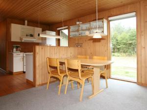 een keuken en eetkamer met een tafel en stoelen bij Four-Bedroom Holiday home in Væggerløse 19 in Bøtø By