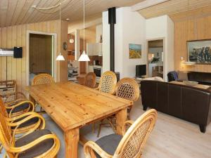 uma sala de jantar com uma mesa de madeira e cadeiras em 10 person holiday home in Jerup em Jerup