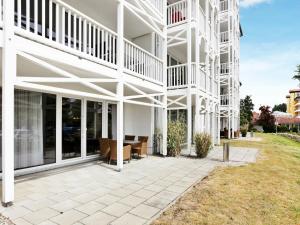 - un bâtiment blanc avec une terrasse en face dans l'établissement 4 person holiday home in Gro enbrode, à Großenbrode