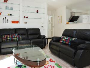 Oddeにある6 person holiday home in Hadsundのリビングルーム(黒い革張りのソファ、ガラステーブル付)