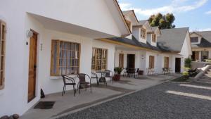 un patio de una casa con sillas y mesas en Cabañas Aires del Bosque en Concón