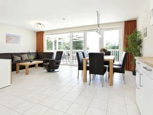 eine Küche und ein Wohnzimmer mit einem Tisch und Stühlen in der Unterkunft 4 person holiday home in Gro enbrode in Großenbrode