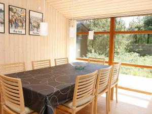 8 person holiday home in Fjerritslev في Torup Strand: غرفة طعام مع طاولة سوداء وكراسي