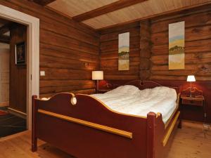 1 dormitorio con 1 cama en una habitación con paredes de madera en 12 person holiday home in F vang, en Tromsnes