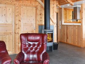 a leather chair sitting in front of a stove at Three-Bedroom Holiday home in Blaksæter in Sølberg