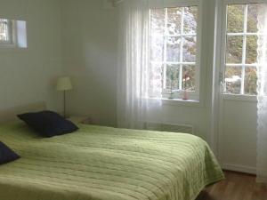 Arkösundにある4 person holiday home in VIKBOLANDETのベッドルーム1室(ベッド1台、緑の掛け布団、窓2つ付)