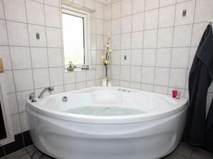 a white tub in a bathroom with a window at 6 person holiday home in Hadsund in Øster Hurup