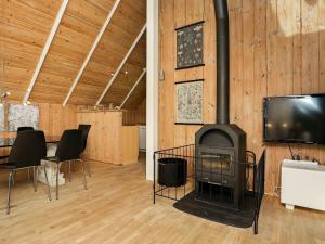 Habitación con chimenea, TV y sillas. en 8 person holiday home in Bl vand en Blåvand