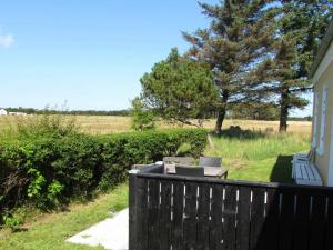 a porch with a wooden fence and a bench at 6 person holiday home in Skagen in Hulsig