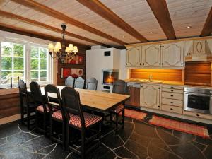 a kitchen with a wooden table and chairs at 8 person holiday home in F vang in Tromsnes