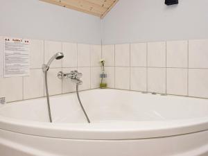 eine Badewanne mit Dusche im Bad in der Unterkunft 8 person holiday home in L kken in Løkken