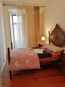 a bedroom with a bed and a window at LisBangla Guest House in Lisbon