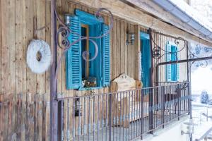 un bâtiment avec des fenêtres bleues et des volets bleus dans l'établissement La FERME des Lombardes, à Saint-Jean-de-Sixt