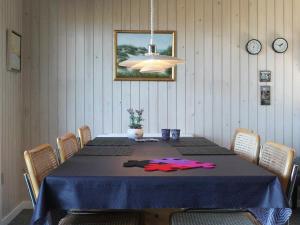 uma sala de jantar com uma mesa com uma toalha de mesa azul em Three-Bedroom Holiday home in Vejby 14 em Blåvand