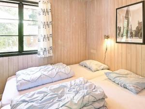 two twin beds in a room with a window at 6 person holiday home in Nex in Snogebæk