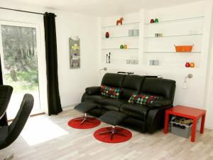 Oddeにある6 person holiday home in Hadsundのリビングルーム(黒い革張りのソファ、テーブル付)