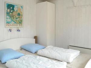 a bedroom with two beds and a painting on the wall at Four-Bedroom Holiday home in Vejers Strand 11 in Vejers Strand