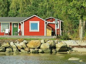a red house with rocks in front of it at 2 person holiday home in SÖLVESBORG-By Traum in Björkenäs