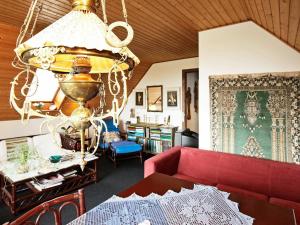 a living room with a red couch and a chandelier at 2 person holiday home in Svendborg in Svendborg