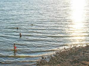 um grupo de pessoas nadando na água em 5 person holiday home in MARIESTAD em Lugnås