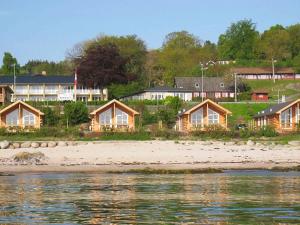 a row of houses on a beach next to the water at 6 person holiday home in Allinge in Allinge