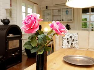 un vase rempli de roses roses sur une table dans l'établissement 6 person holiday home in L s, à Læsø