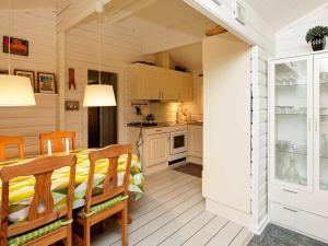 a kitchen and dining room with a table and chairs at 6 person holiday home in L s in Læsø
