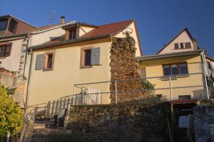 une maison avec un mur en pierre devant elle dans l'établissement Le Zell, à Zellenberg