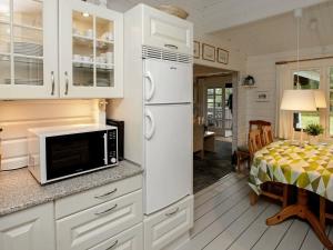a kitchen with a white refrigerator and a dining room at 6 person holiday home in L s in Læsø