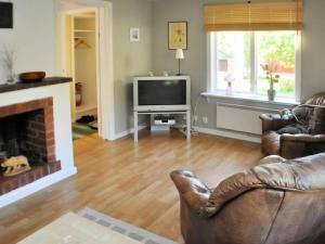 a living room with a couch and a television at 5 person holiday home in ARVIKA in Arvika