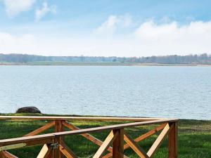 a wooden fence next to a large body of water at 5 person holiday home in MARIESTAD in Lugnås