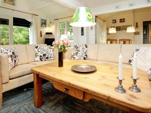 un soggiorno con divano e tavolo con candele di 6 person holiday home in L s a Læsø