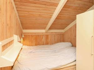 ÅlbækにあるHoliday home Ålbæk XIIの木製の天井の客室のベッド1台分です。