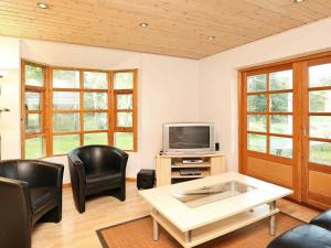 - un salon avec des chaises noires et une télévision dans l'établissement 6 person holiday home in L s, à Læsø