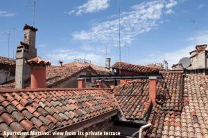 a view of roofs of buildings with the words urban lighting view from its purple terr at Aria e Luce Suites a Venezia in Venice