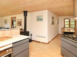 a kitchen with a stove and a dining room at 6 person holiday home in L s in Læsø