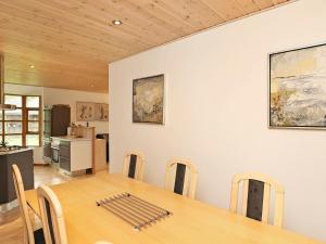 a dining room with a table and a kitchen at 6 person holiday home in L s in Læsø