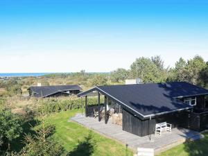 ヒアツハルスにあるHoliday home Hirtshals IIIのデッキ付きの黒い家の頭上の景色