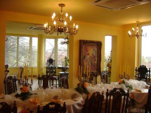 a dining room with tables and chairs and a chandelier at U Marii Hotel in Gorzów Wielkopolski