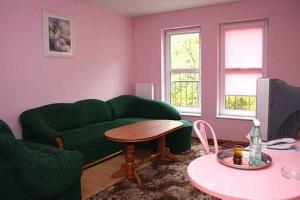 a living room with a green couch and a table at Noclegi u Marii in Gorzów Wielkopolski