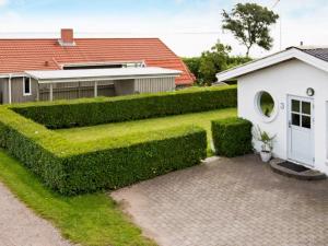 a garden with a hedge next to a house at 6 person holiday home in Malling in Malling