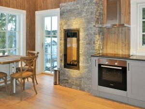 a kitchen with a stone fireplace next to a table at 5 person holiday home in F vang in Favang