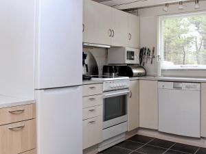 cocina con electrodomésticos blancos y nevera blanca en 6 person holiday home in Oksb l, en Mosevrå