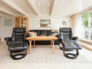 Mosevråにある6 person holiday home in Oksb lのリビングルーム(ソファ、テーブル、椅子付)