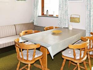 ein Wohnzimmer mit einem Tisch, Stühlen und einem Sofa in der Unterkunft 4 person holiday home in Nex in Tjørneby