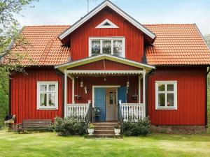 una casa rossa con una porta blu di Holiday home ÖRSJÖ a Örsjö