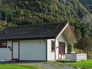 SeljeにあるHoliday Home Rundereimの山前赤縁の小さな白い家